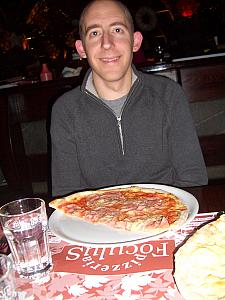 Jay smiling before eating a yummy pizza.