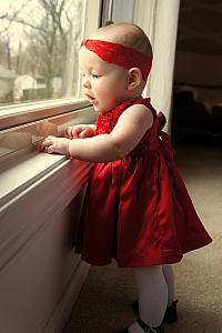 Holding herself up on the windowsill! (She is still very wobbly, Dad is just off camera ready for the save.)