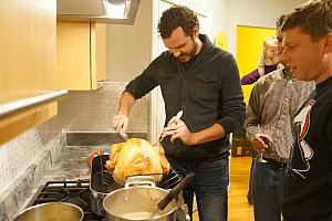Adam slicing up the turkey while Brian instructs.