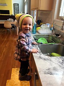 Wearing daddy's hat and playing in the sink