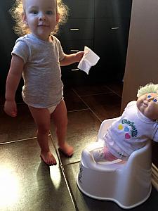 Capri teaching her doll how to use the potty