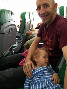 On the airplane to Split - Capri found a comfy place to nap, on dad's lap.